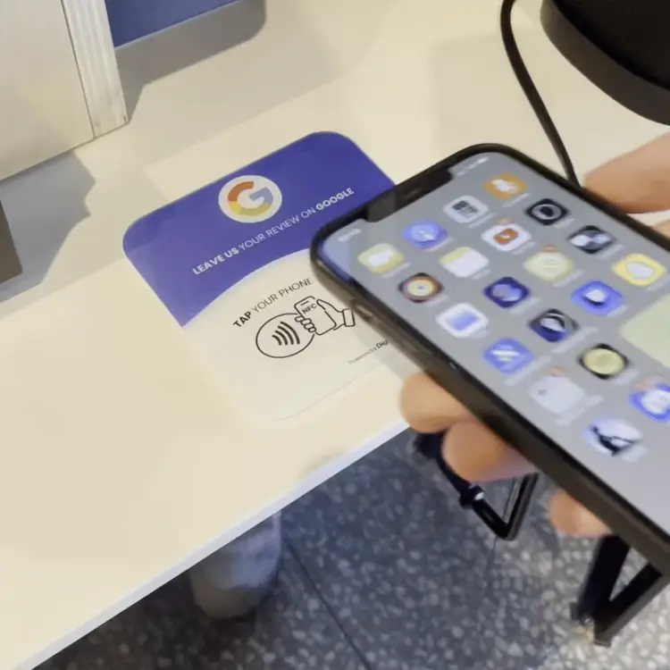 Un client tape son téléphone sur le support NFC pour laisser un avis Google en 3 secondes